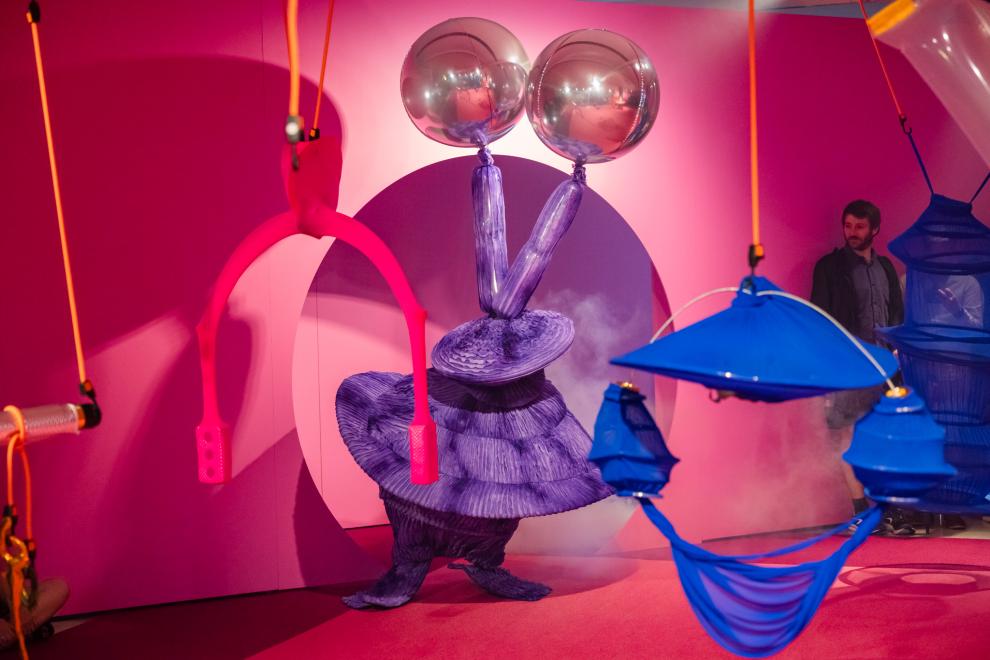 A person in a purple costume with a silver balloon headdress