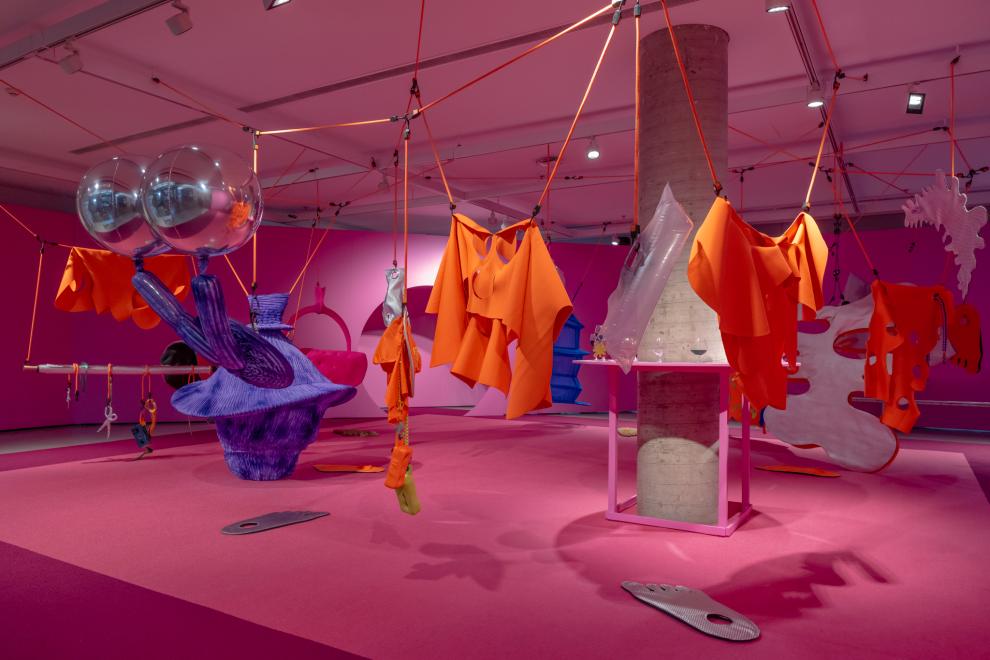A colourful art installation in a room painted pink
