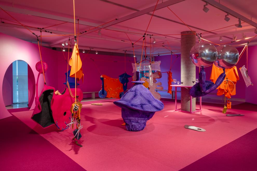 A colourful art installation in a room painted pink