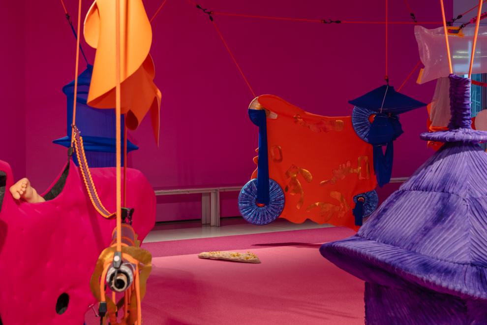 A colourful art installation in a room painted pink