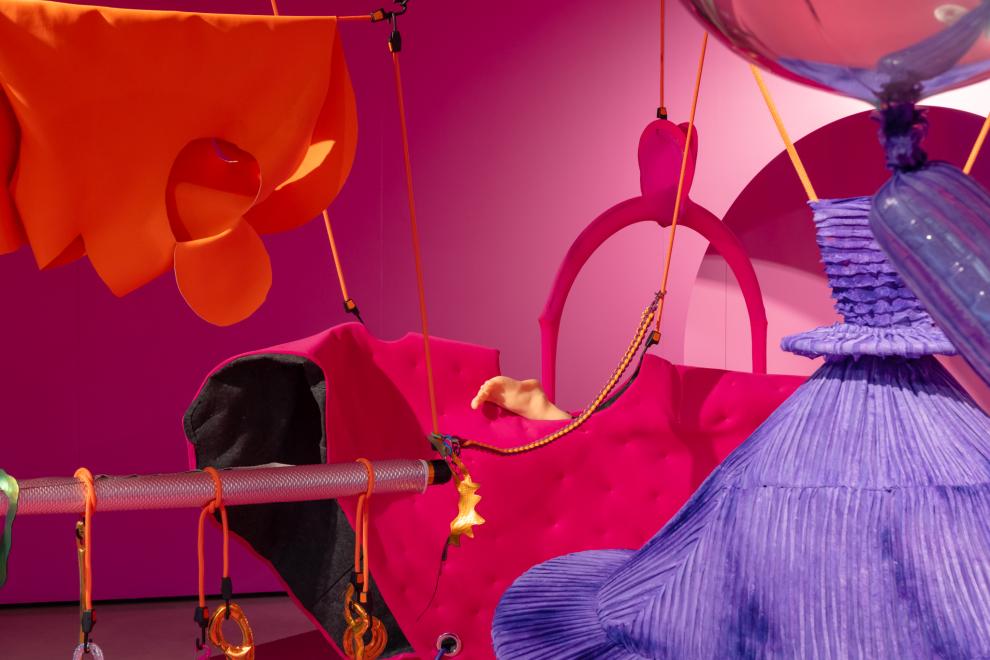 A colourful art installation in a room painted pink