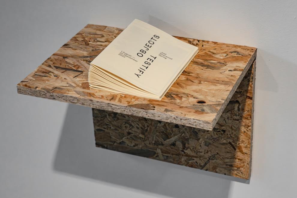  small pamplhet with the text "OBJECTS TESTIFY" sits on a shelf