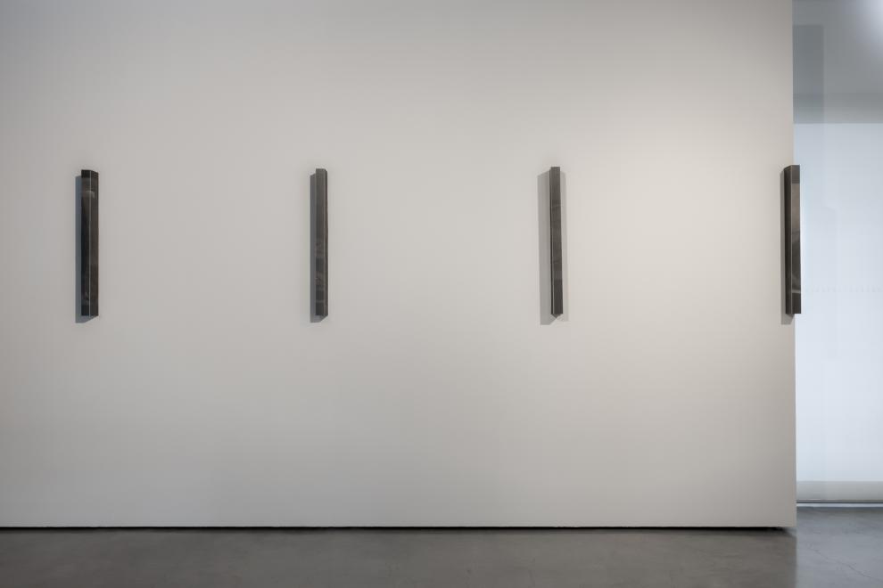 Four delicate graphite on paper artworks on a white wall