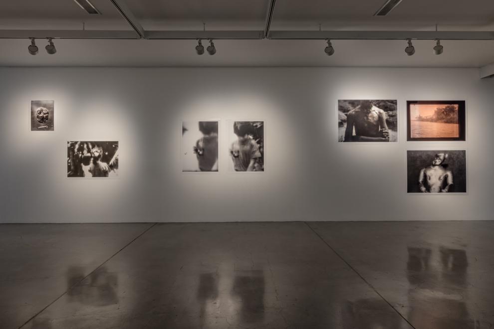 A photograph which shows a gallery installation of pinned black and white photographs