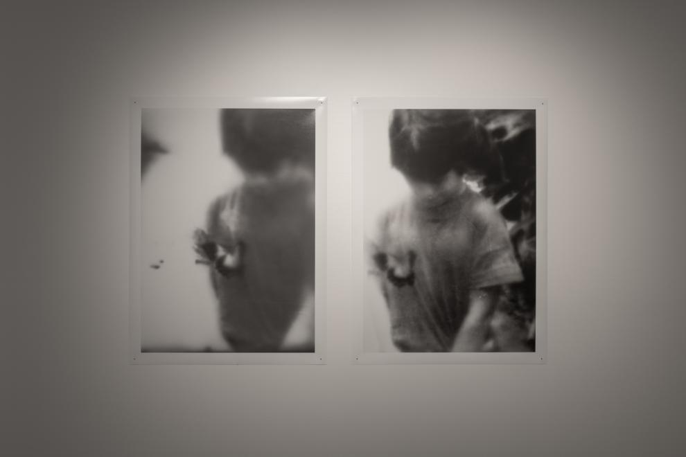 A photograph of two black and white photgraphs of a small child with a butterfly on their shirt