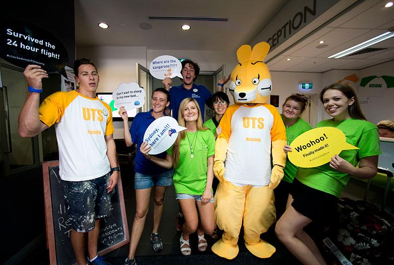 Group of people holding signs and a mascot