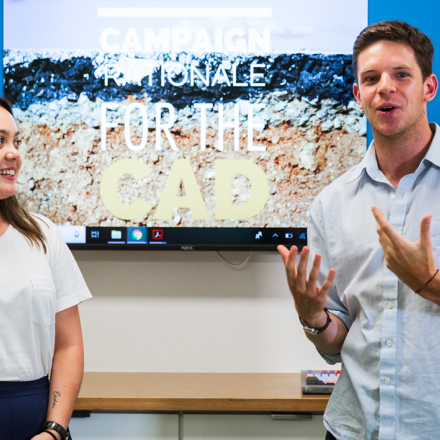 Two students pitching in front of a presentation