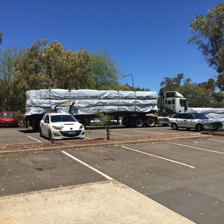 Parking lot with construction truck and parked cars