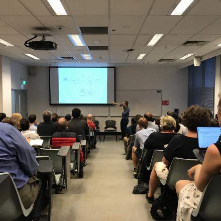 A lecture theatre full of people listening to a seminar