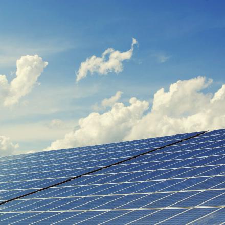 Blue solar panels with blue sky and white clouds