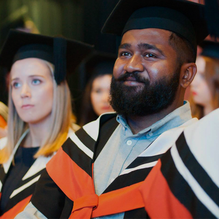 A male and female student at a graduation ceremony