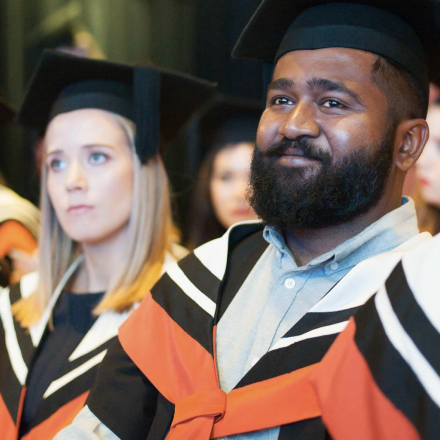 A male and female student at a graduation ceremony