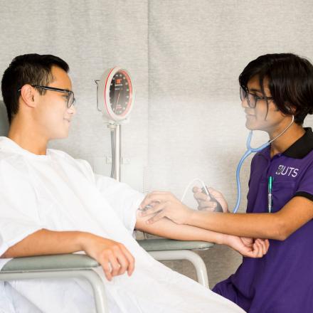 A male UTS nursing student takes a patients blood pressure