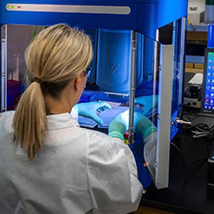 Female researcher in PPE with plastic vials