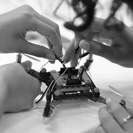 School student and UTS academic working on a drone.