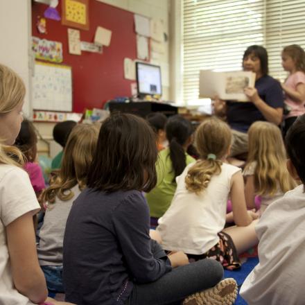 A classroom with a group of students sitting on the floor