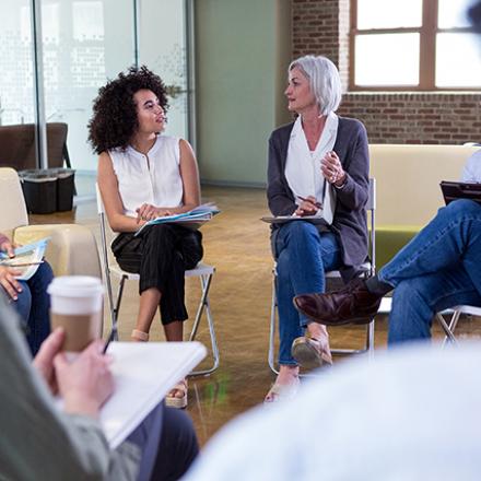 People sitting in a circle with pen and paper