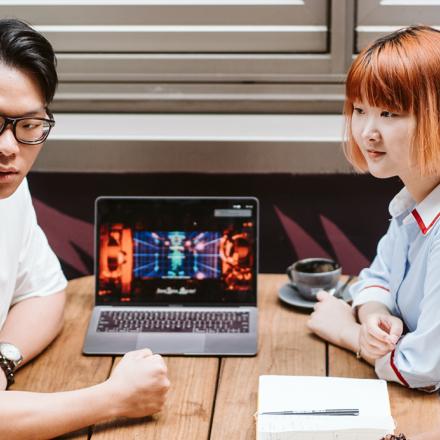 Collaborating around a laptop at a cafe table