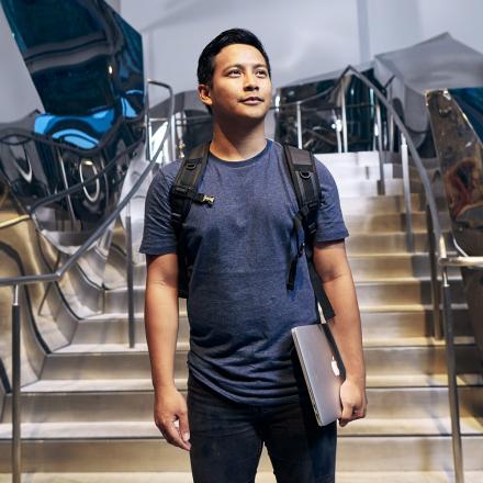 young man with laptop and backpack