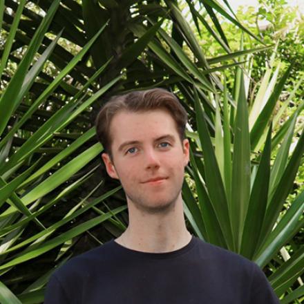 James Ardma with a verdant green leafy background