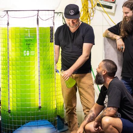 Three men and a bright green piece of scientific machinery