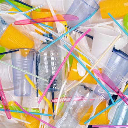 Plastic bottles, cups, cutlery and colorful plastic straws