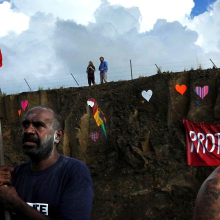 Protestors, placards, aboriginal flag