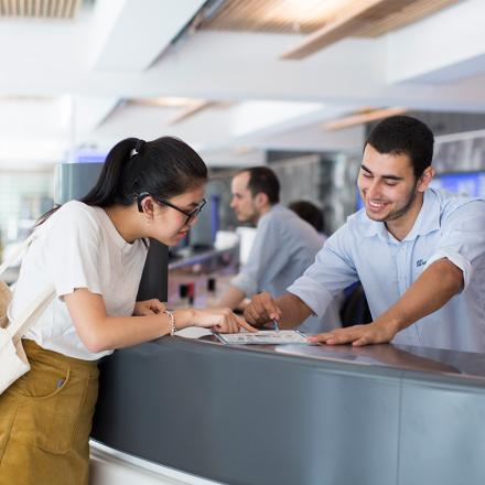 A student with a hearing aid talking to an advisor at the UTS Student Centre