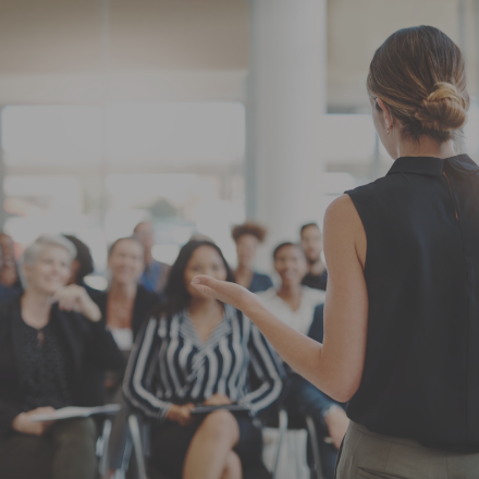 women delivering presentation to seated group