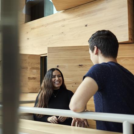 Two people facing each other while talking casually inside a building