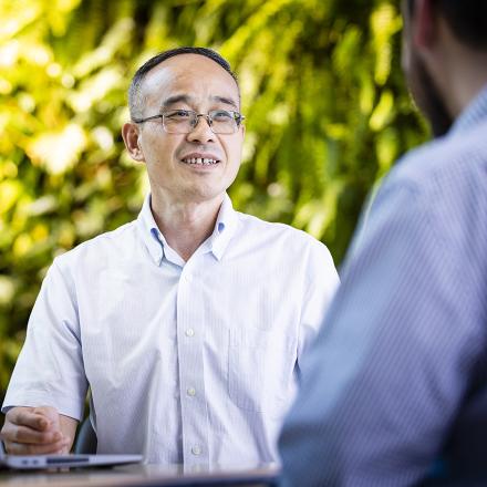 A CGT researcher talking to another person who has their back to the camera