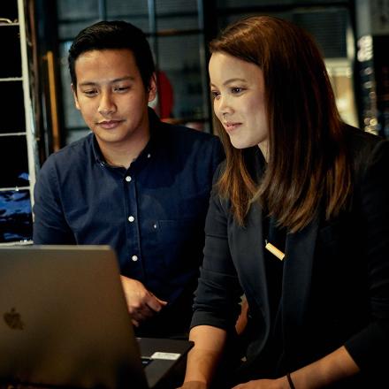 Two postgrad students looking at a laptop screen