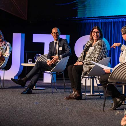 Amani Haydar, Nicholas Stewart and Sarah Dale on stage with Professor Anita Stuhmcke