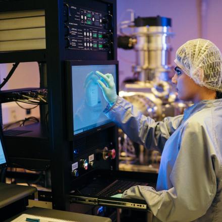 Ritika Bazzard SQA Student conducting an experiment in a lab environment. Ritika is looking at a touch screen with her hand raised up it.