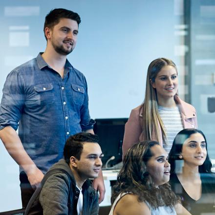 Students watch a screen