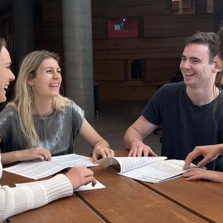 Holly Rewell, Abigail Woods, Matt Neilson and Keily Ting sitting at an outside table working together on the Piping Hot project