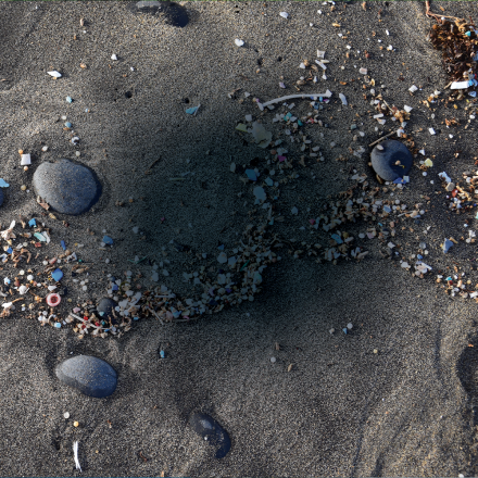 Microplastics washed up on a black sand beach