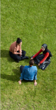 Three UTS students sitting together outside at alumni green