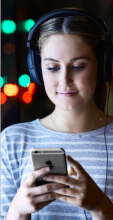 UTS student wearing headphones and engaged with her mobile phone