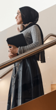 UTS persona carrying laptop while walking down the staircase on campus