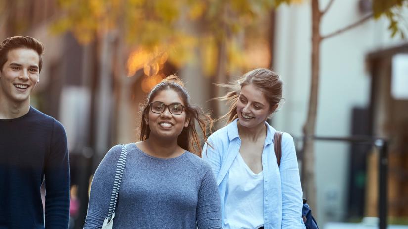 three students walking down a laneway near the UTS campus in the late afternoon