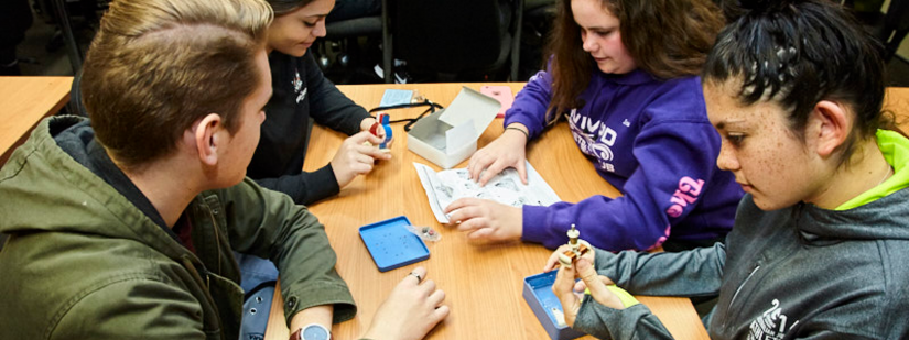 A group of students investigate parts of electronic equipment