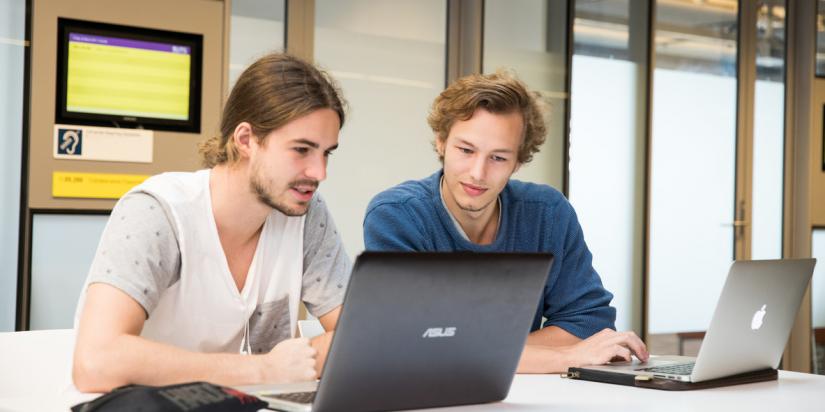 Two male students working on their laptops