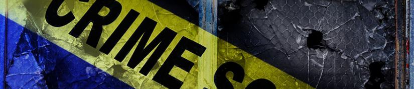 Crime scene tape on glass with bullet hole