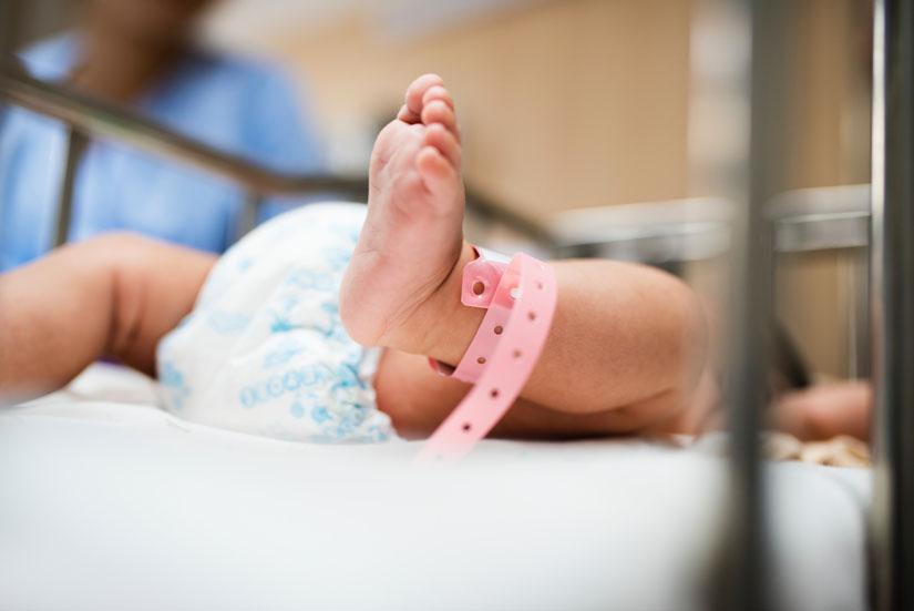 Close up of a baby's foot in a hospital crib