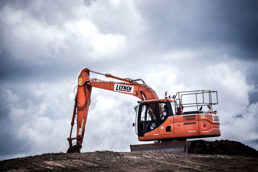 Orange-coloured construction equipment on top of a mound of dirt