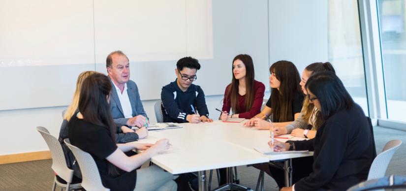 A group of students sitting around a table writing notes