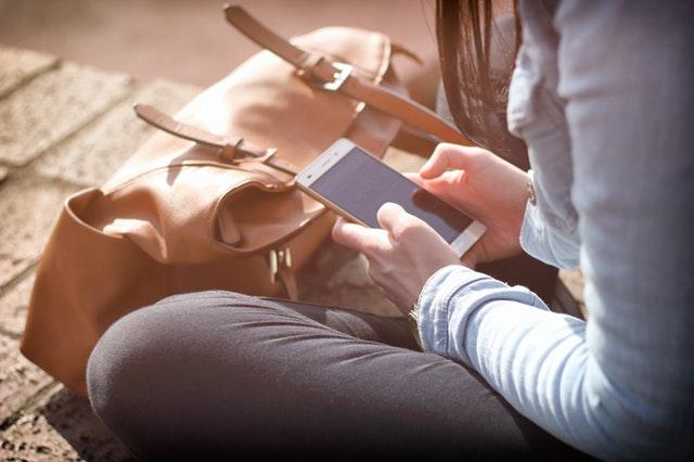 Young person sitting using a mobile phone