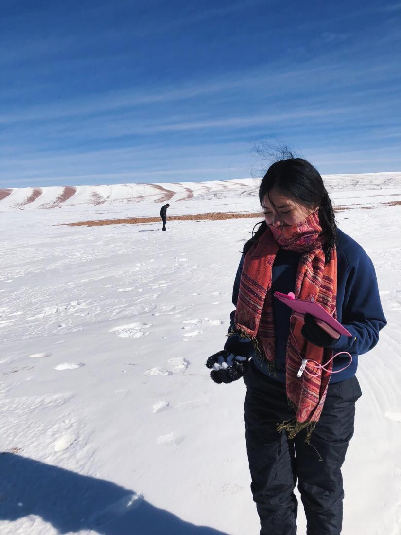 Rochelle standing on the snow fields holding a snowball