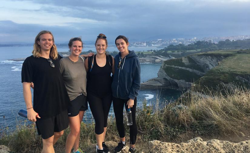 FASS ICS Spain study tour Ben and three female friends standing on a cliff overlooking the sea